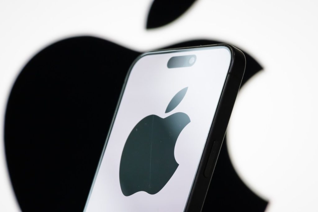 Apple hires iPhone camera app Halide’s co-founder for its design team In this photo illustration, the logo of Apple Inc. is displayed on a smartphone screen, with the company's iconic black apple symbol visible in the background.