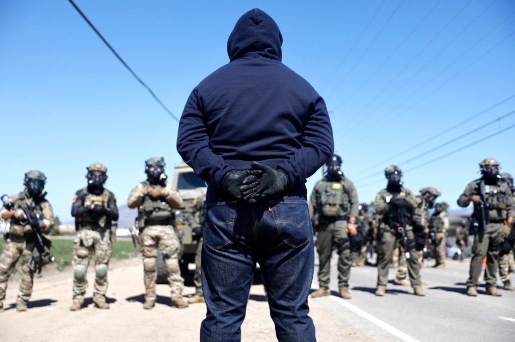 Federal agents block people protesting an ICE immigration raid at a nearby licensed cannabis farm on July 10, 2025 near Camarillo, California.
