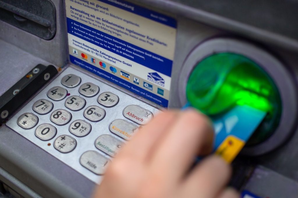 FBI says ATM ‘jackpotting’ attacks are on the rise, and netting hackers millions in stolen cash a close-up photo of a person punching in their PIN on an ATM in a wall.